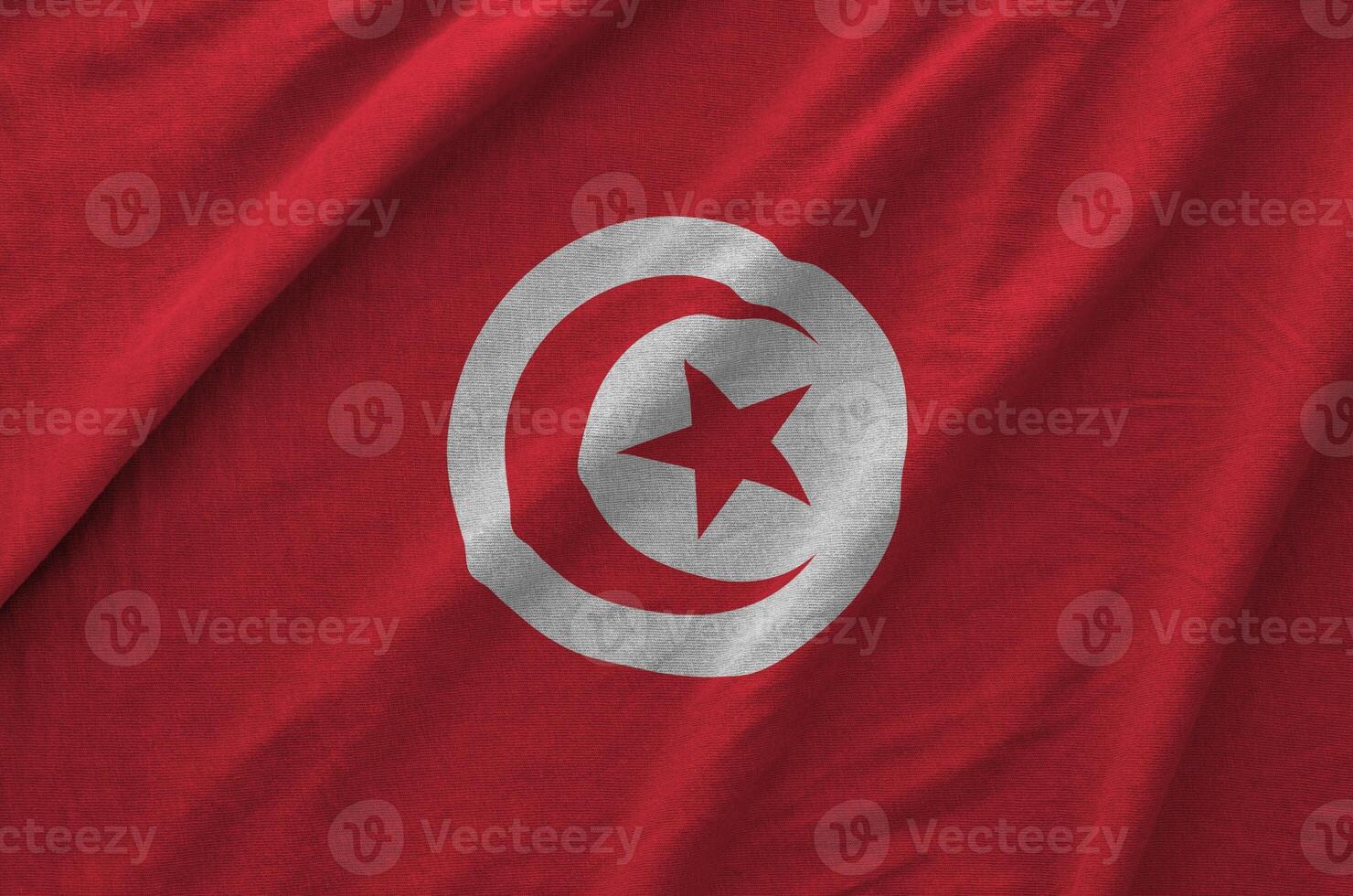 Tunisia flag depicted on folded wavy fabric of old cloth photo