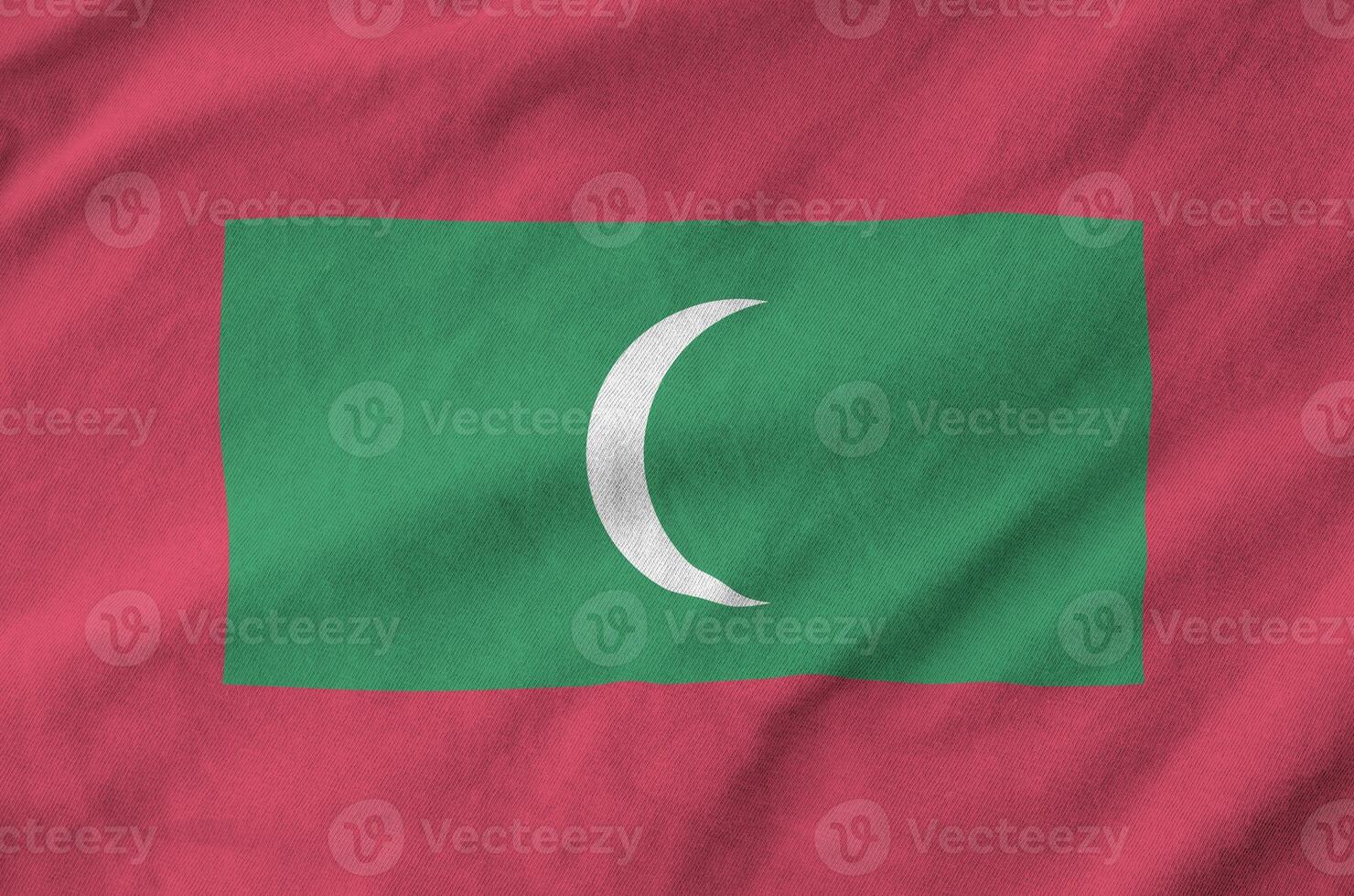 Maldives flag depicted on folded wavy fabric of old cloth photo