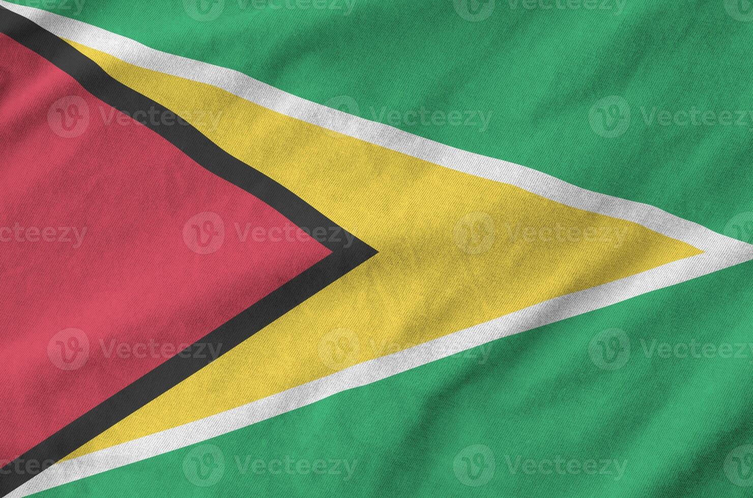 Guyana flag depicted on folded wavy fabric of old cloth photo