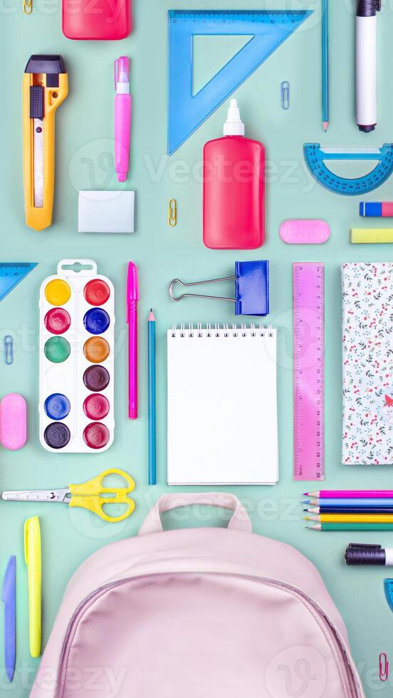 Composition of multi-colored stationery items, school supplies laid out on the table. office, school FLAT LAY . Back to school, vertical banner, school bag photo