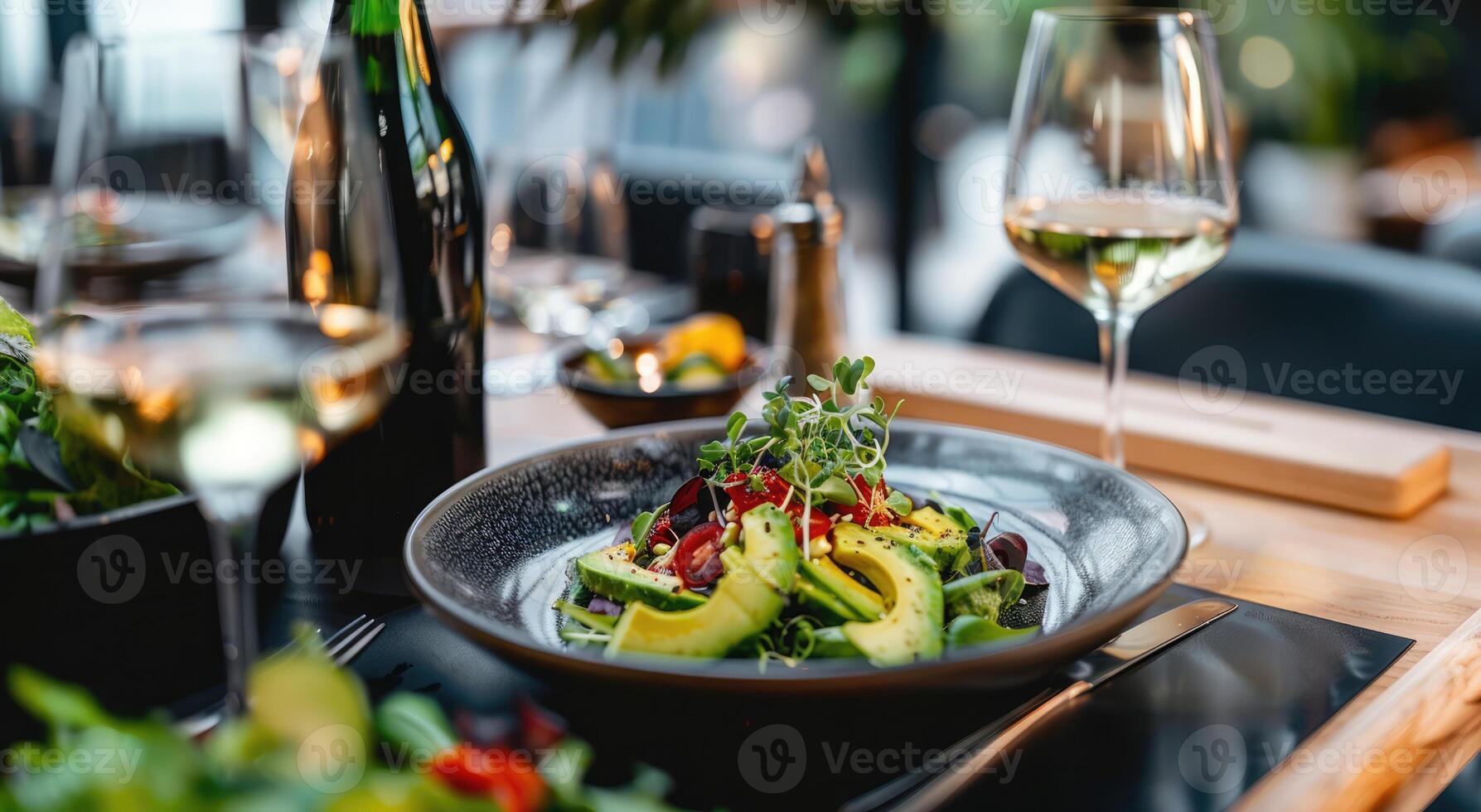 Enjoying a fresh craft green salad paired with wine at an elegant restaurant during dinner time photo