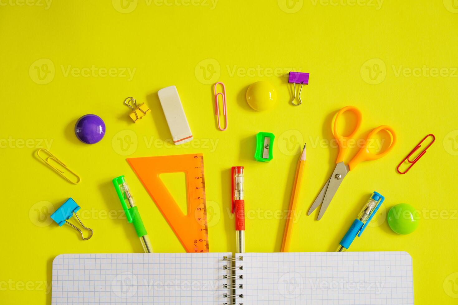 Notebook on a spring for notes and stationery lie on a yellow background photo