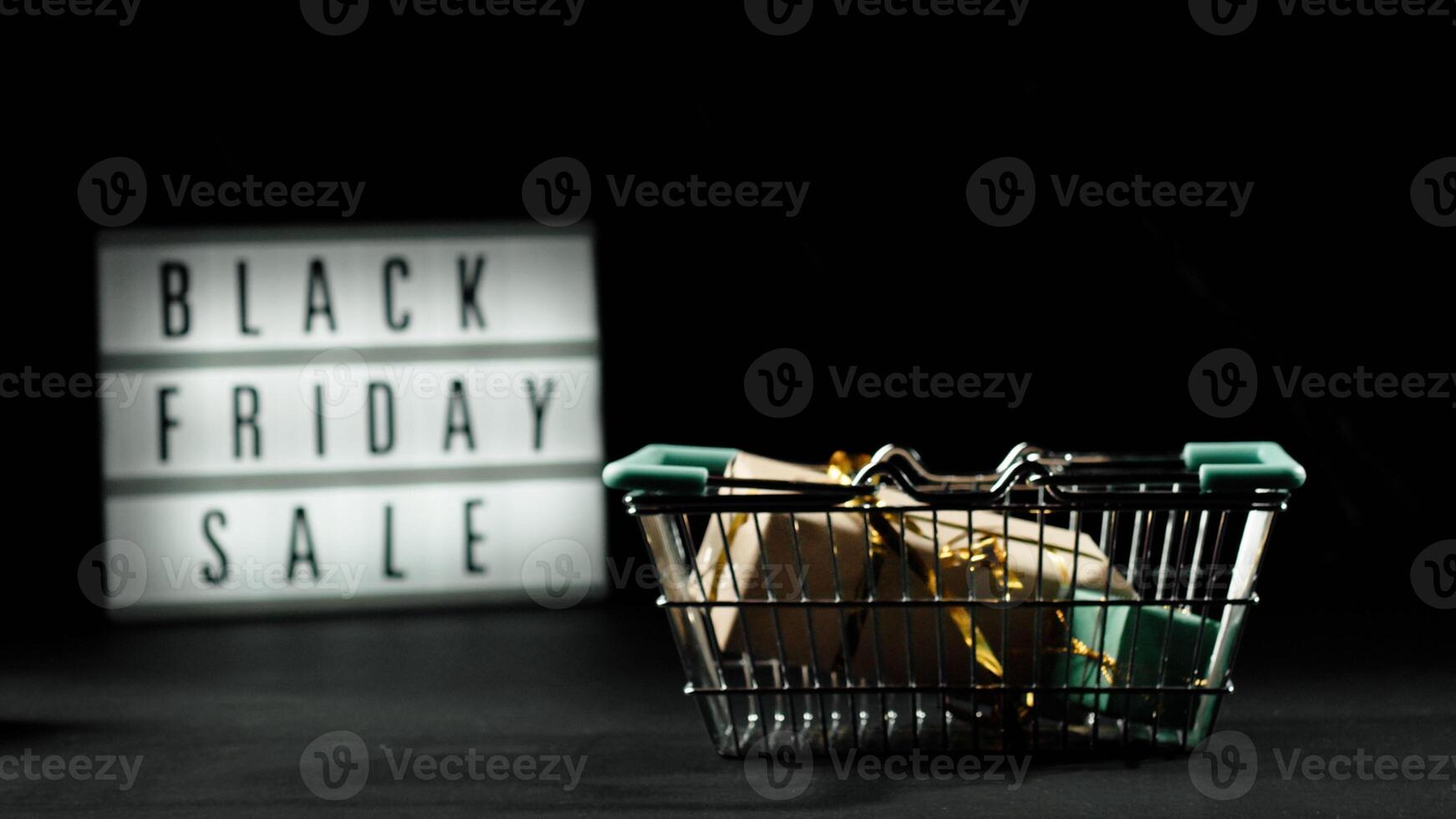 Black Friday concept. Mini shopping cart and Light box with text BLACK FRIDAY SALE on a black background. Online sale and discounts photo