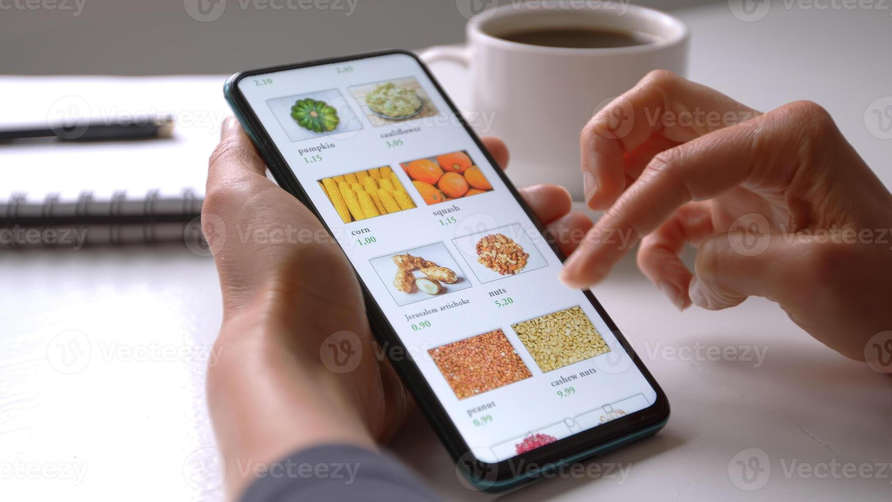 Woman using smartphone buys food online in the internet shop store. Woman's hand on the mobile phone screen selects the goods remotely at home . photo