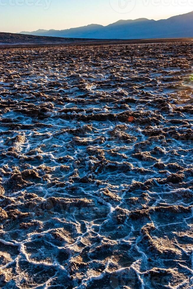 Salt plateau of self-sedimented salt cracked in the heat of the sun in the desert in Death Valley, Death Valley National Park, California photo