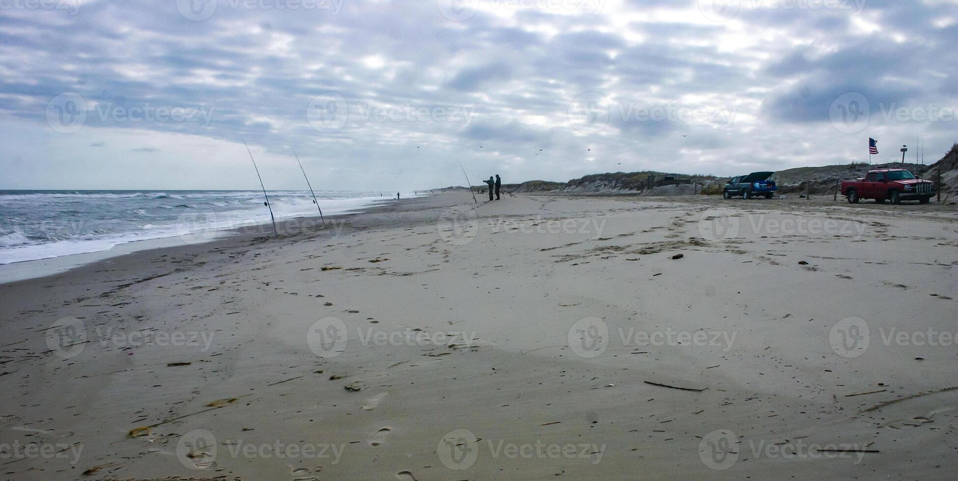 Fishermen on the sandy shore of the Atlantic Ocean in New Jersey, USA photo