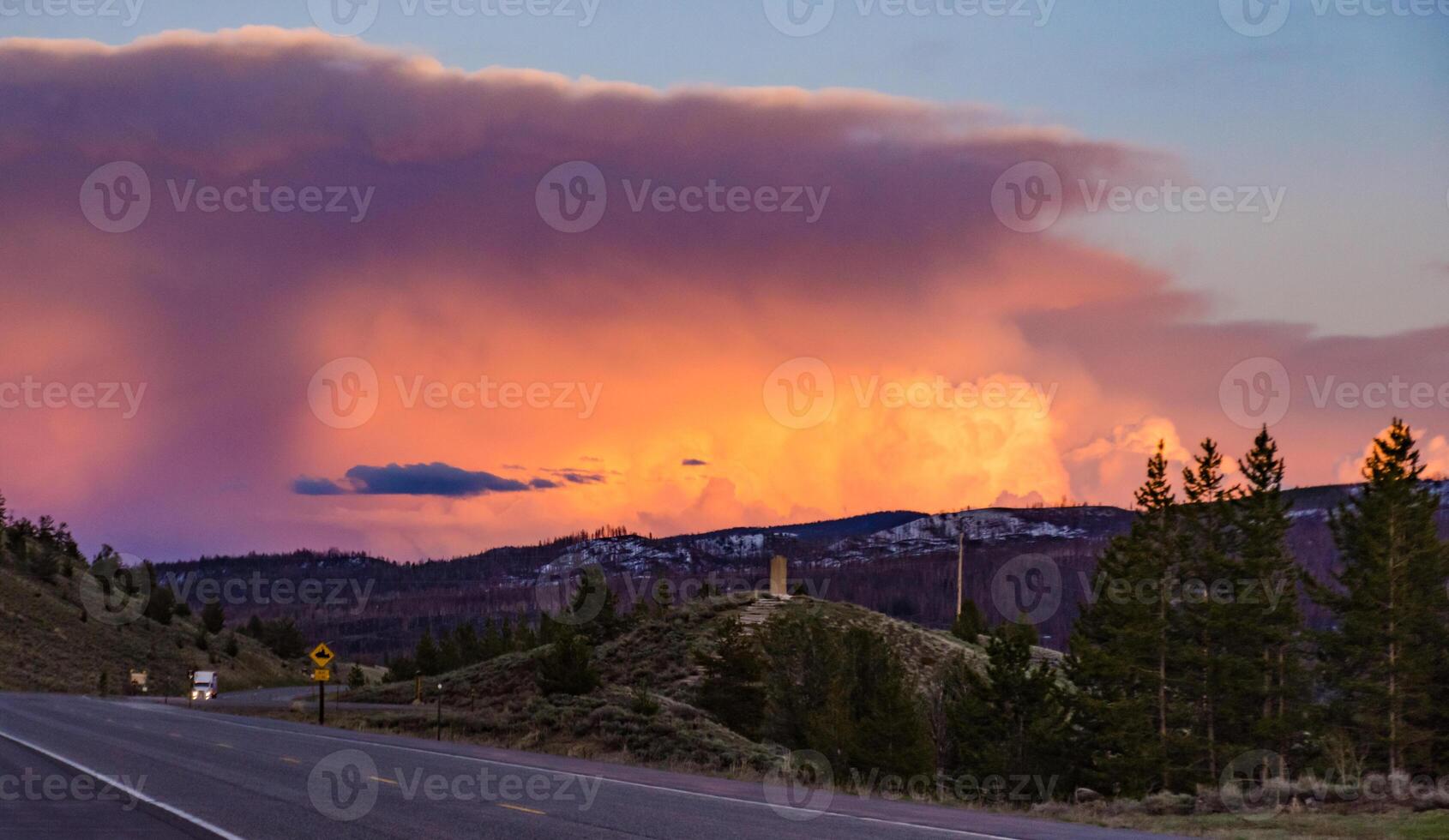 Beautiful red sunset over the mountains, car on the road. US photo
