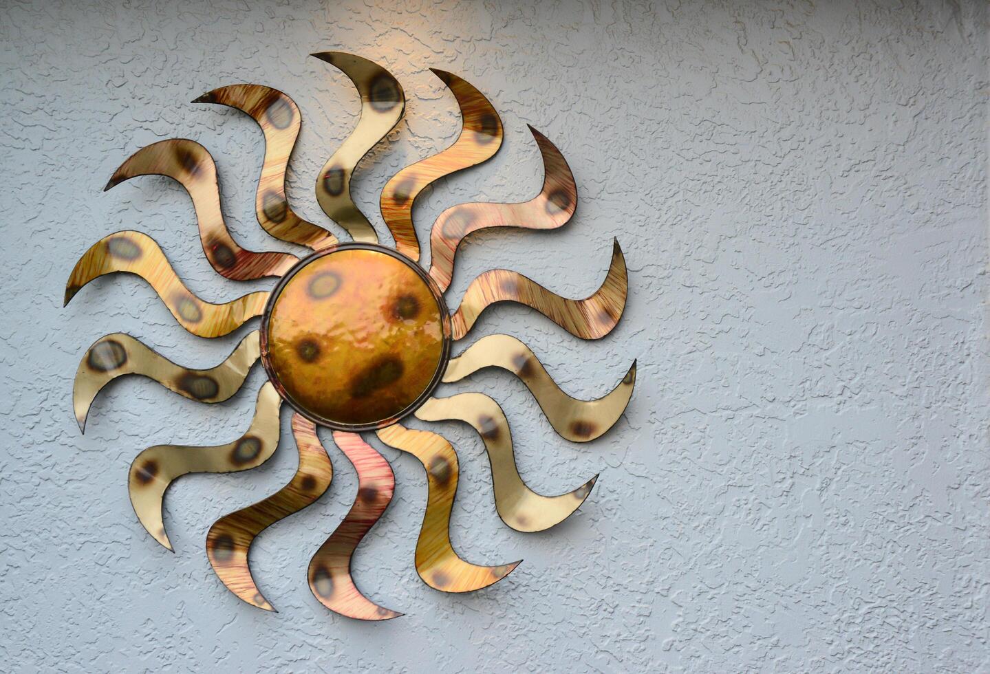 NEW MEXICO, USA - NOVEMBER 22, 2019 copper decoration in the form of the sun on a stone wall, New Mexico photo