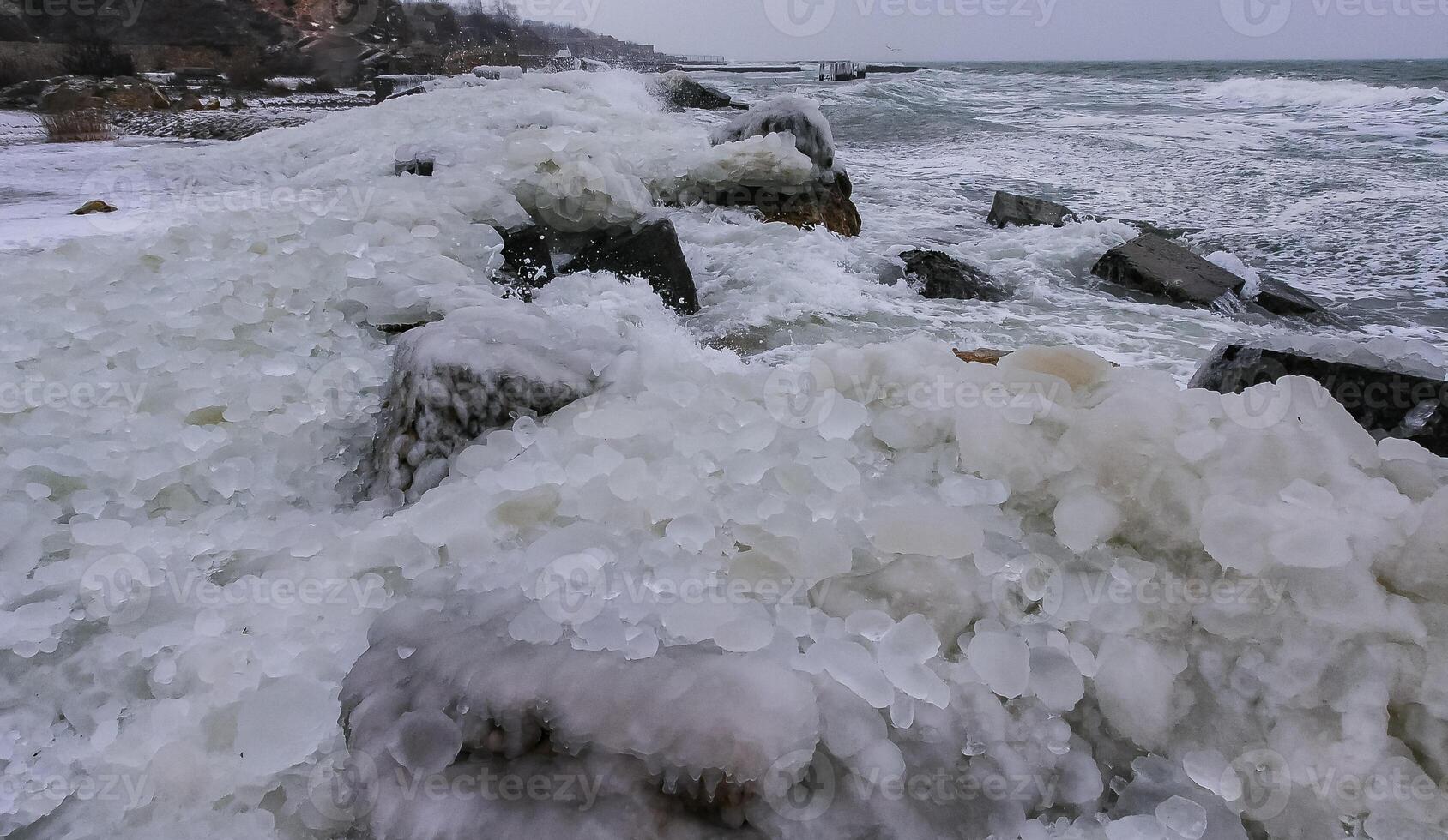 Frozen Black Sea, ice-covered and frozen coastal rocks in the piers, harsh winter photo