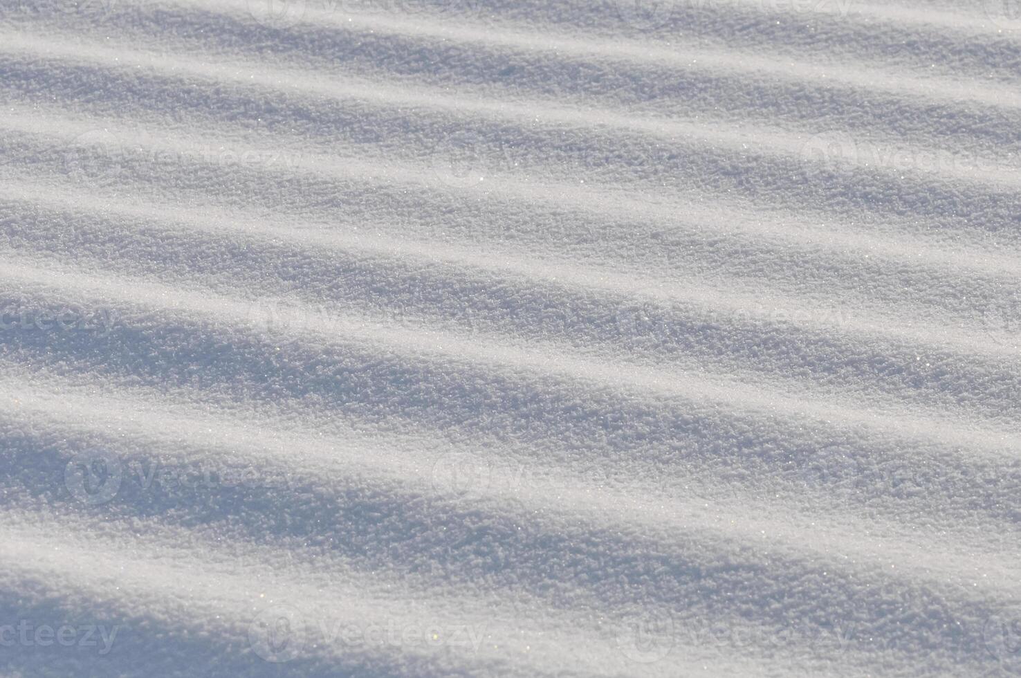 Snow lies in waves in a cold snowy winter, the play of light in straight lines photo