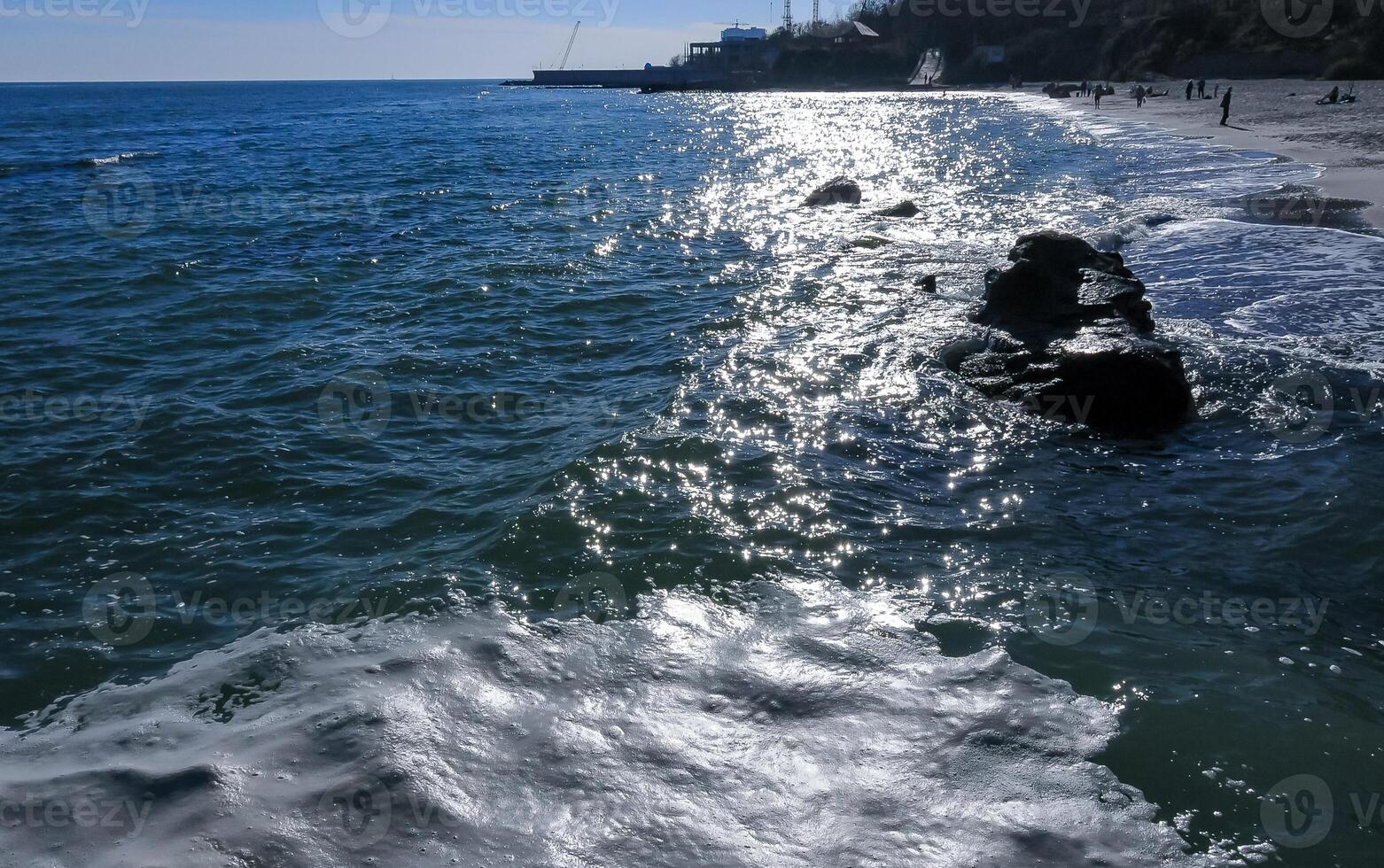 Bright glare and white foam on the water on a sunny day near the Black Sea coast photo