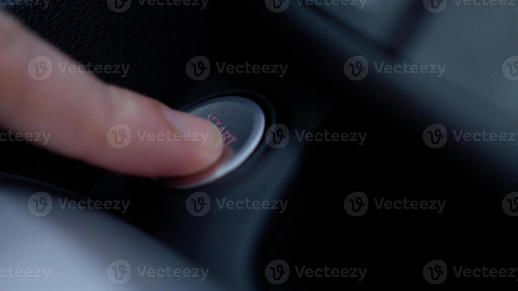 Finger pressing engine start button on car The driver pushing on automatic start stop button. photo
