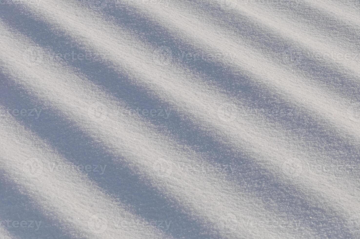 Snow lies in waves in a cold snowy winter, the play of light in straight lines photo