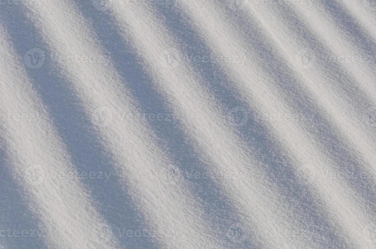 Snow lies in waves in a cold snowy winter, the play of light in straight lines photo