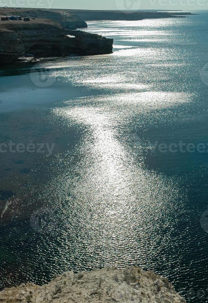 A path of sun glare on the water against the blue sky near the rocks on Tarkhankut, Atlesh photo