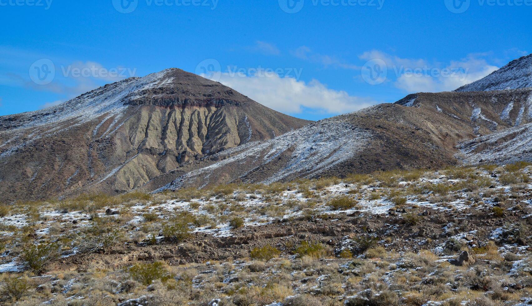 Snow in the mountains, Snow-covered mountain pass, desert plants under the snow in summer photo