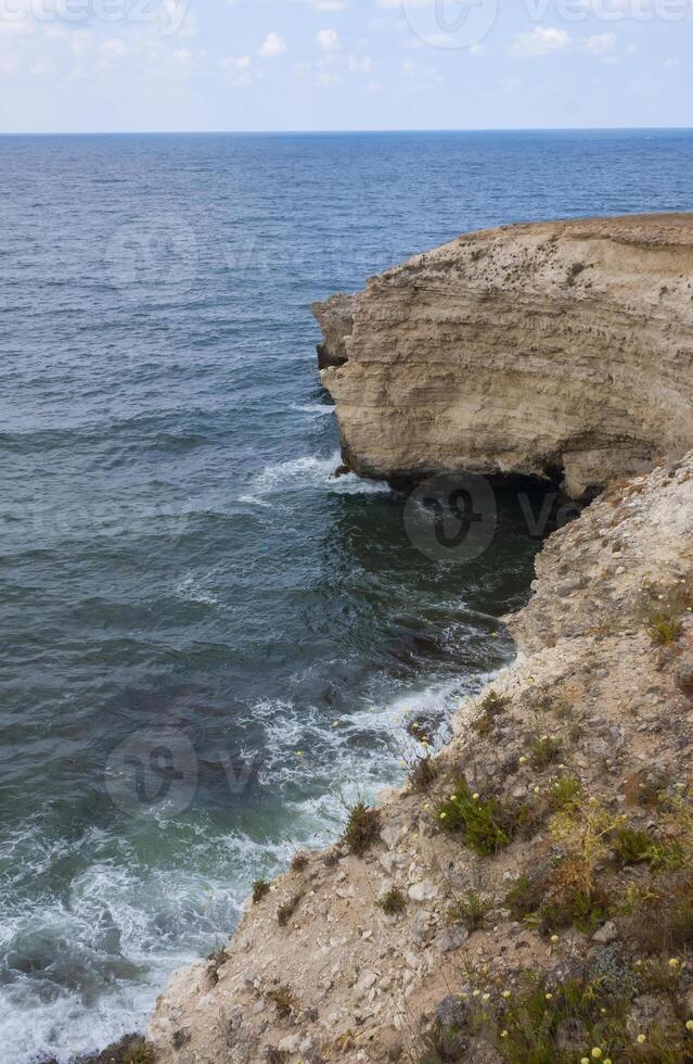 High limestone coastal cliffs against the backdrop of the Black Sea on Tarkhankut, Atlesh, western Crimea photo