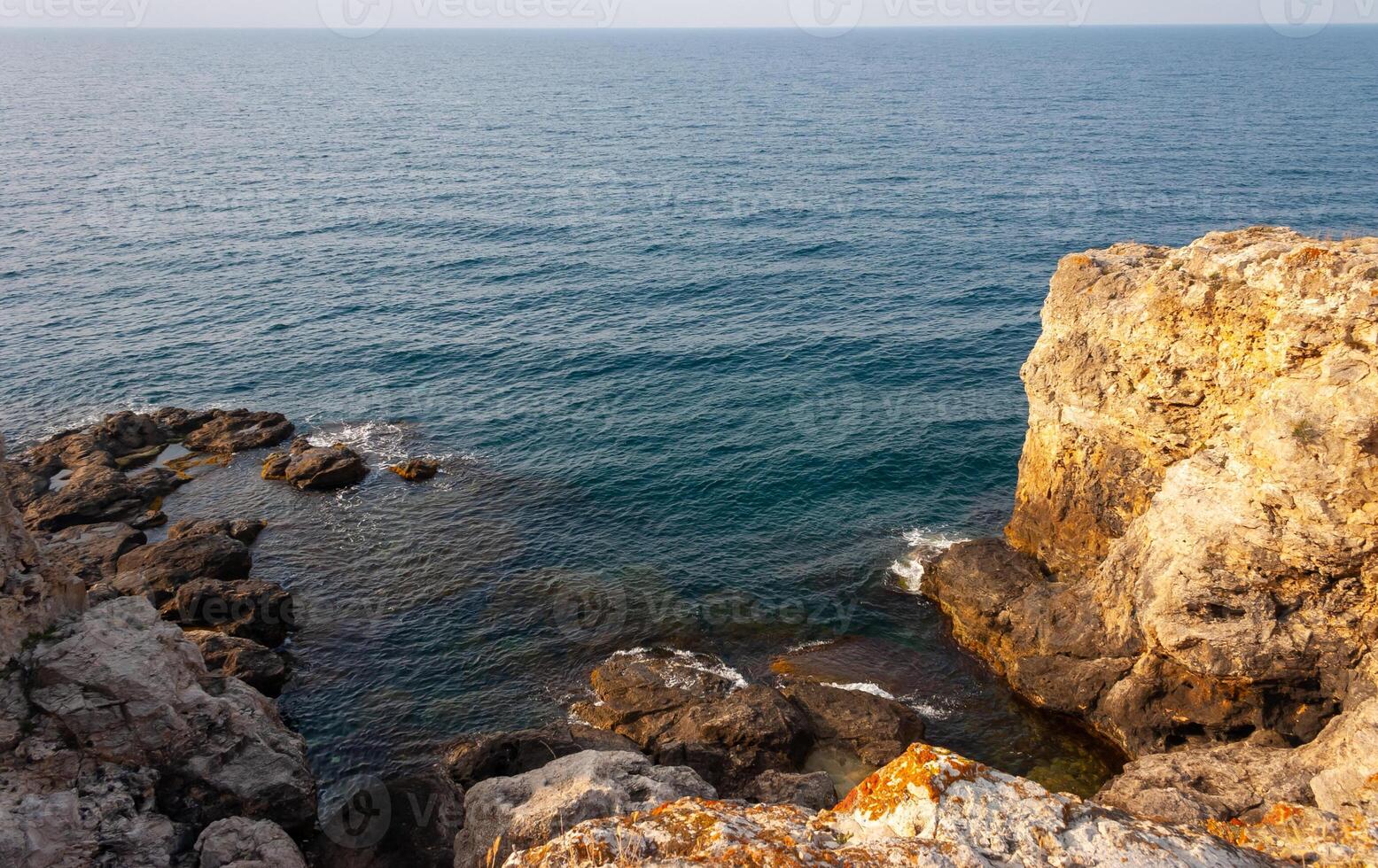 High limestone coastal cliffs against the backdrop of the Black Sea on Tarkhankut, Atlesh, western Crimea photo