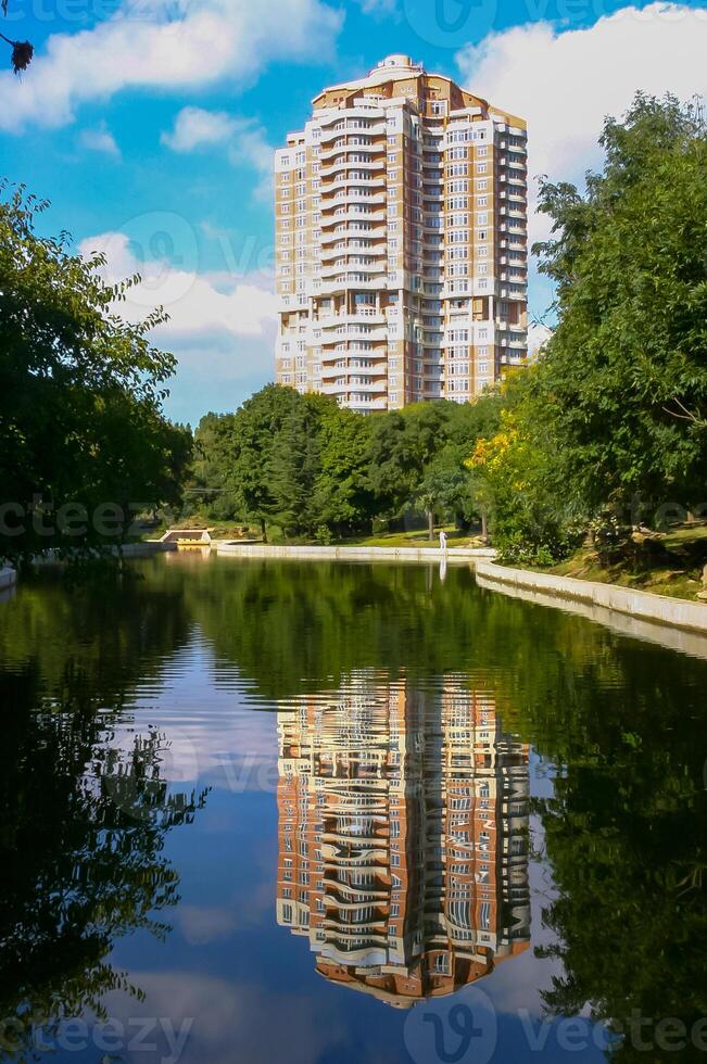 Reflection of a large house in the water of an artificial lake photo