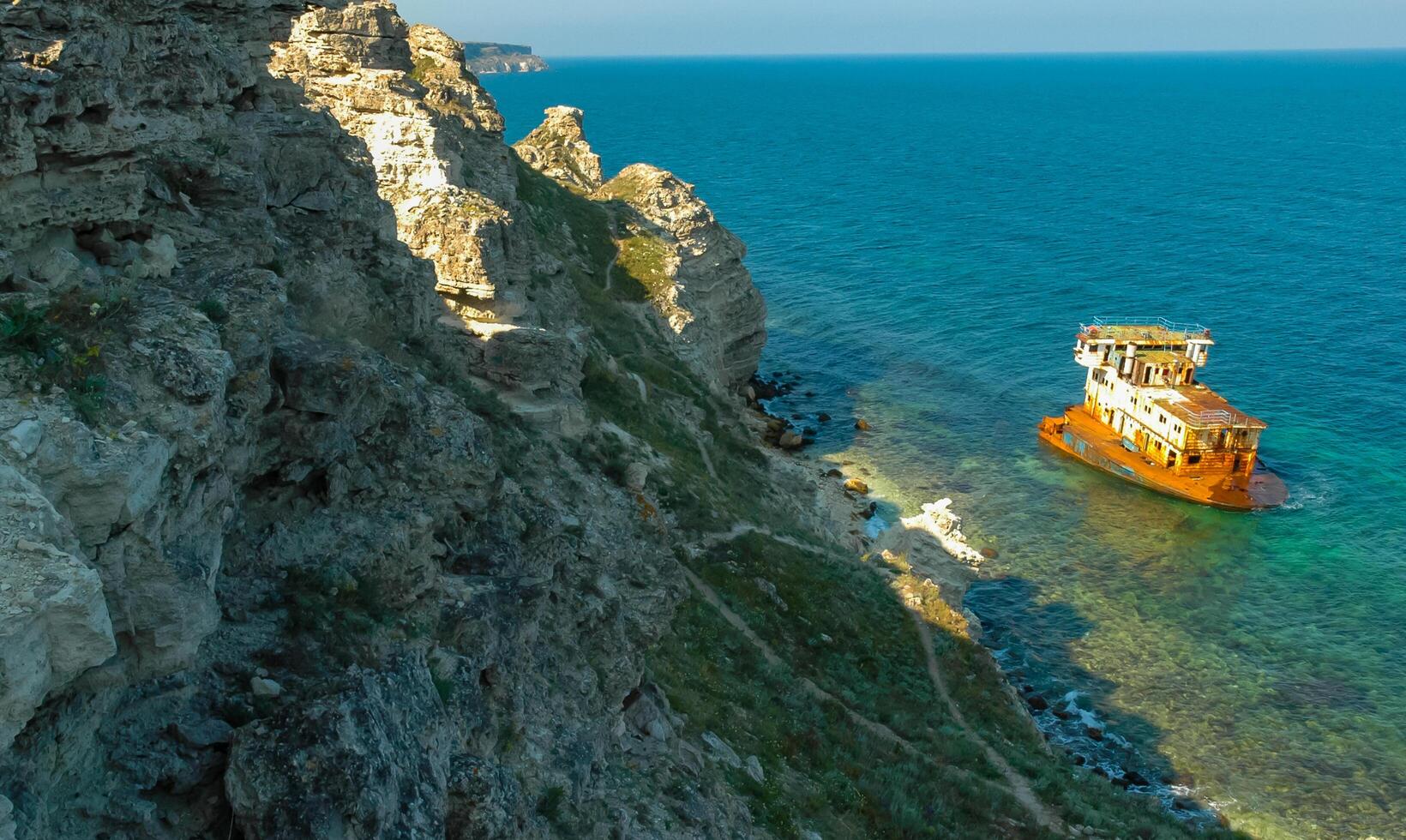The remains of a sunken ship near the coastal cliffs in the tract Dzhangul, western Crimea photo