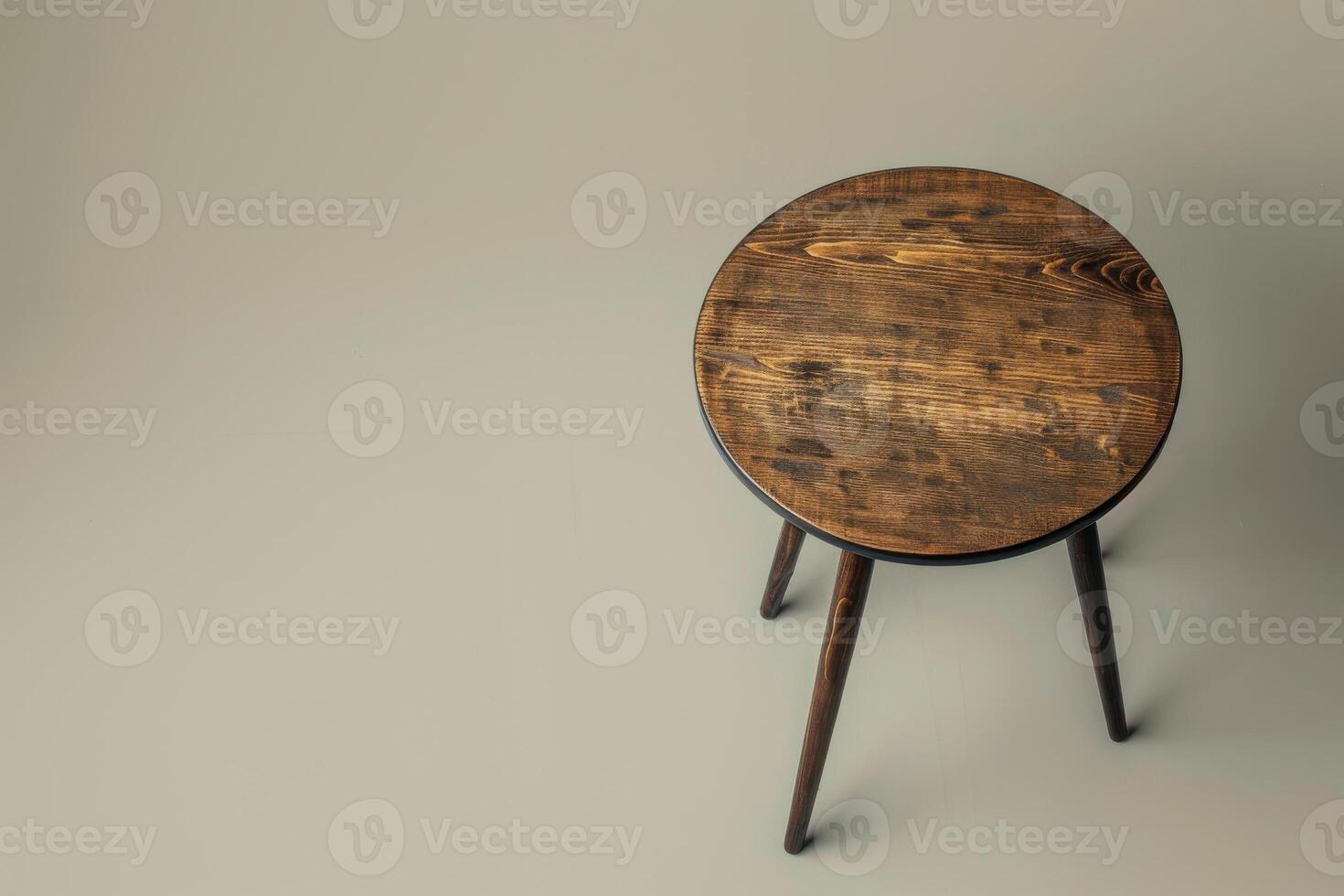 Rustic round wooden stool on a neutral backdrop, showcasing craftsmanship and simplicity in design photo