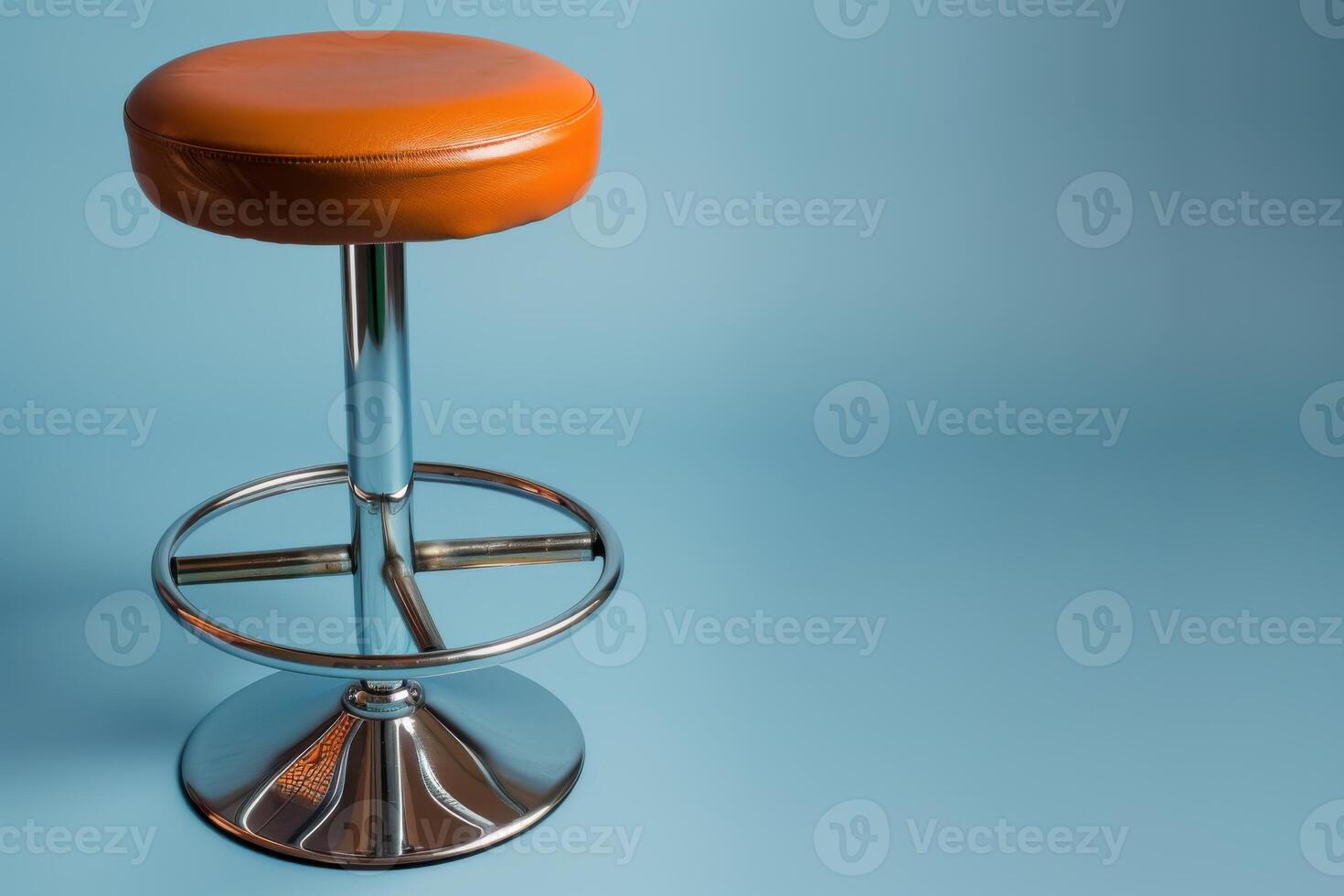 A stylish orange bar stool against a soft blue backdrop in a modern studio setting photo