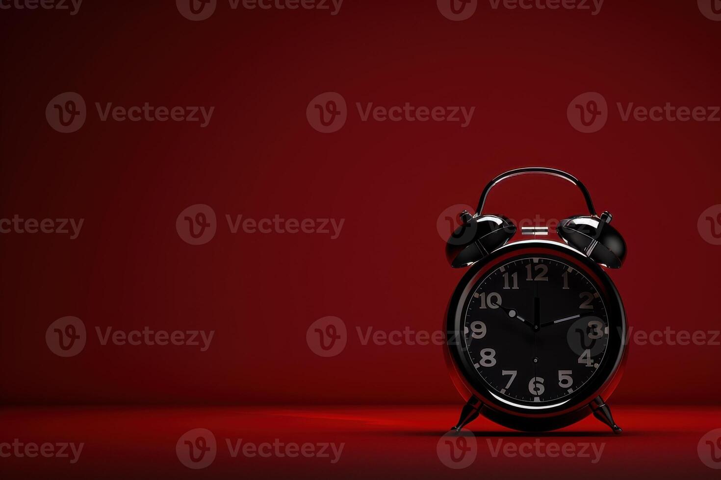 A vintage black alarm clock stands out against a striking red backdrop, capturing the essence of time on a quiet afternoon photo