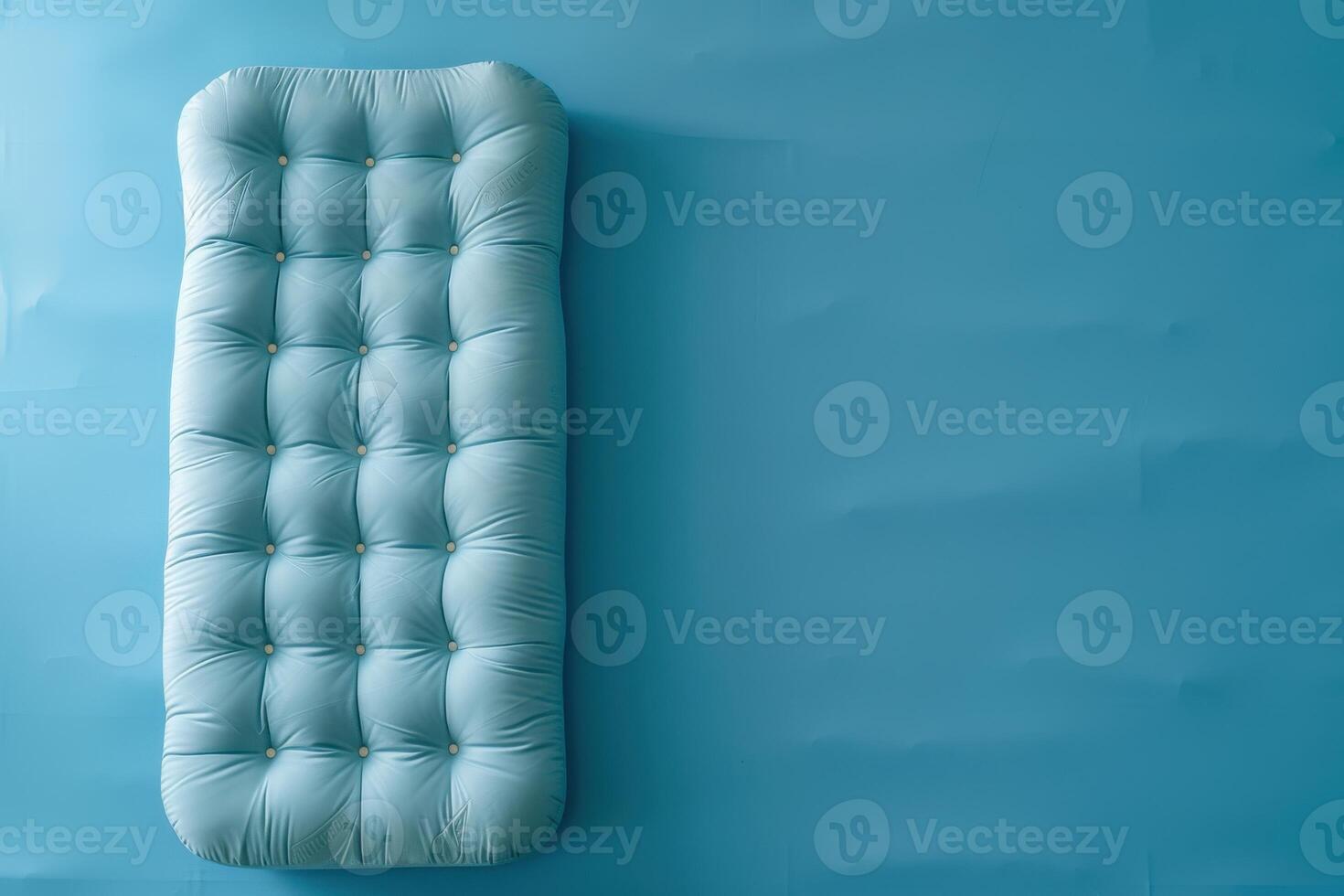 Cozy vintage mattress on a soft blue background creating a serene atmosphere in a minimalist space photo