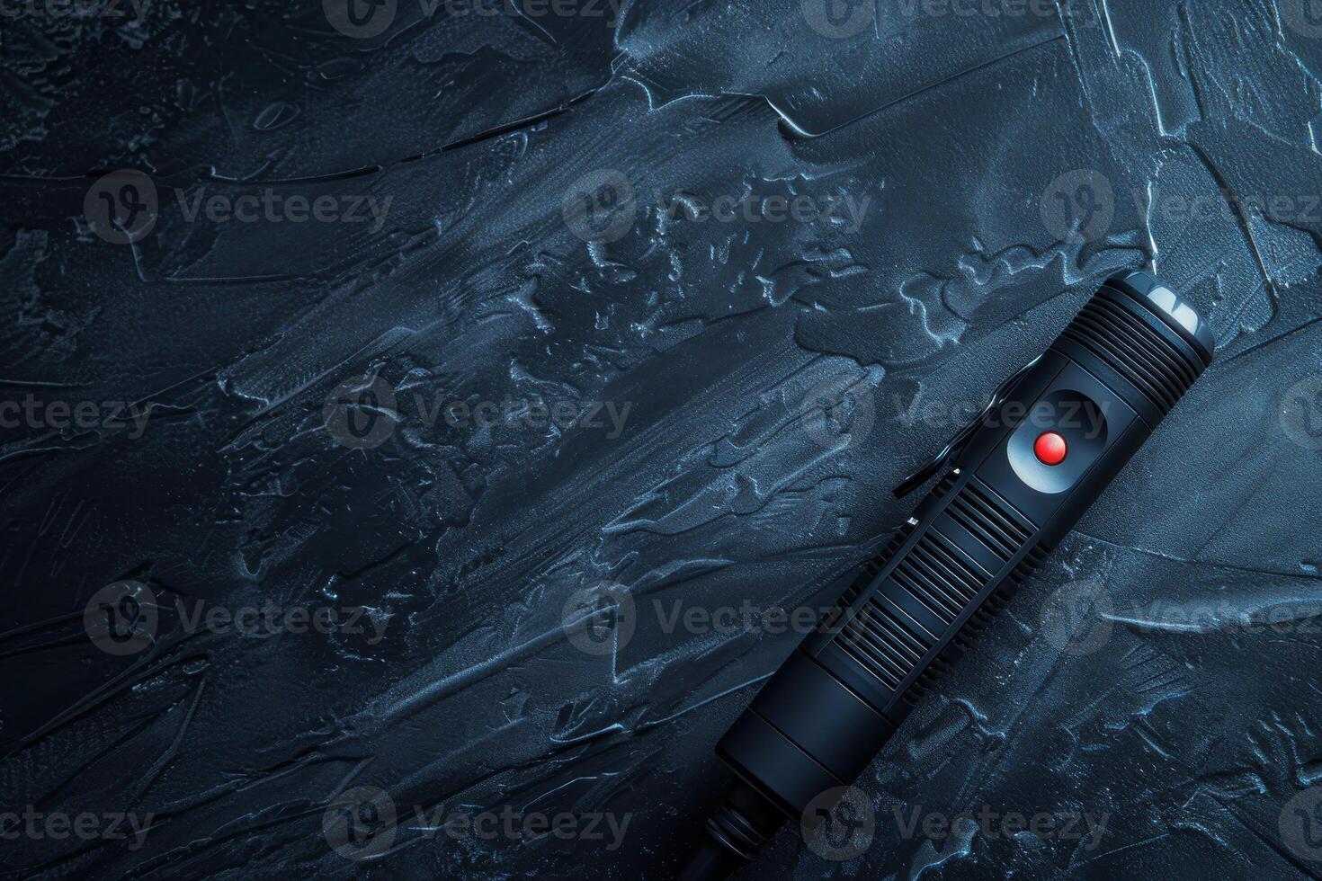 A sleek black laser pointer resting on a textured dark surface, illuminated by a soft light during a quiet evening photo