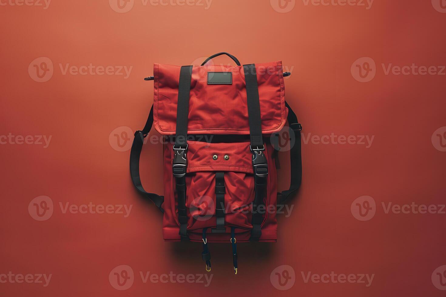 A vibrant red backpack against a warm orange backdrop, highlighting its sturdy design and functional features photo