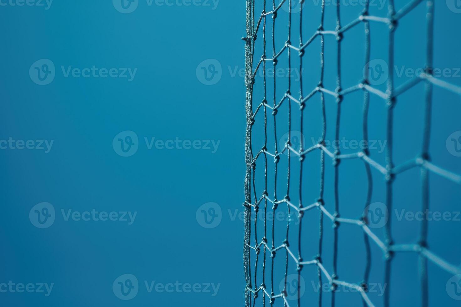 A close-up view of a delicate net against a serene blue background in a tranquil outdoor setting during midday photo