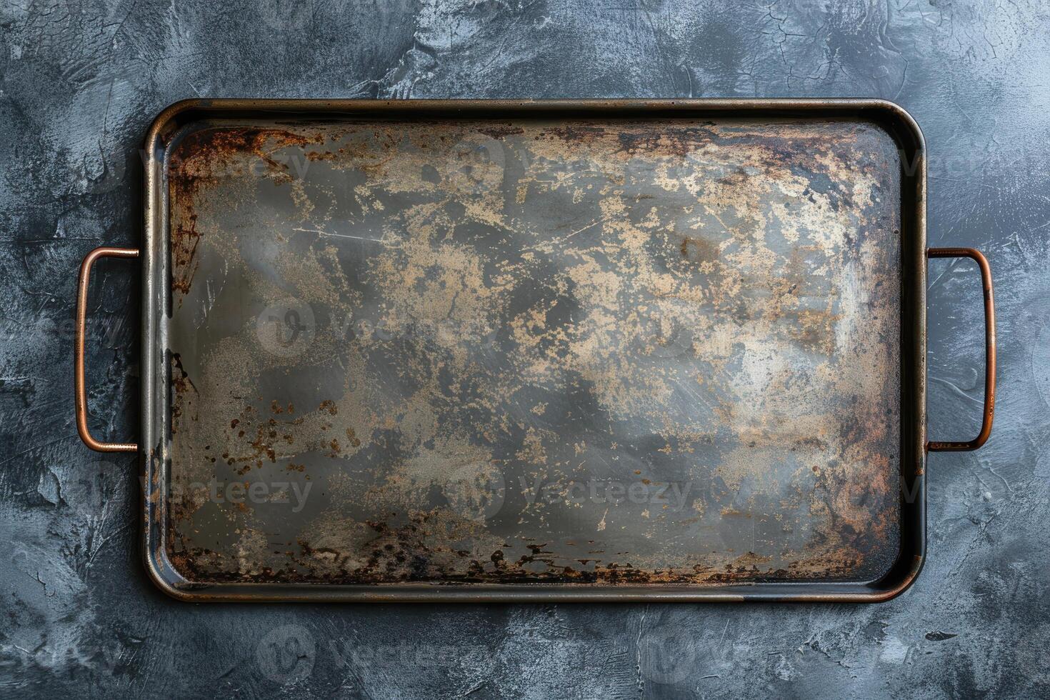 An aged baking tray resting on a textured blue backdrop, evoking memories of countless culinary creations in a cozy kitchen photo