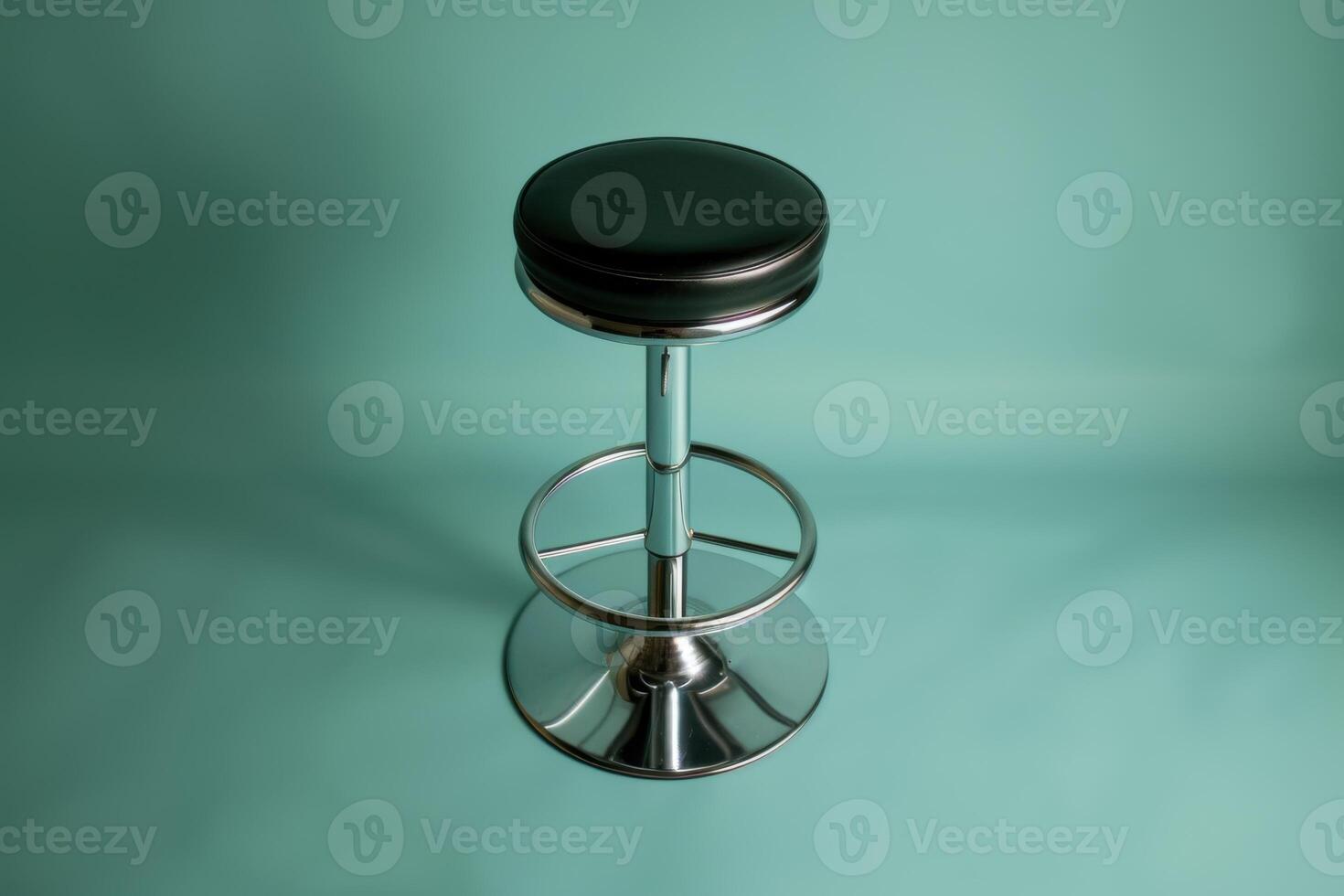 A sleek black bar stool stands elegantly against a calming turquoise backdrop, inviting relaxation in a modern setting photo