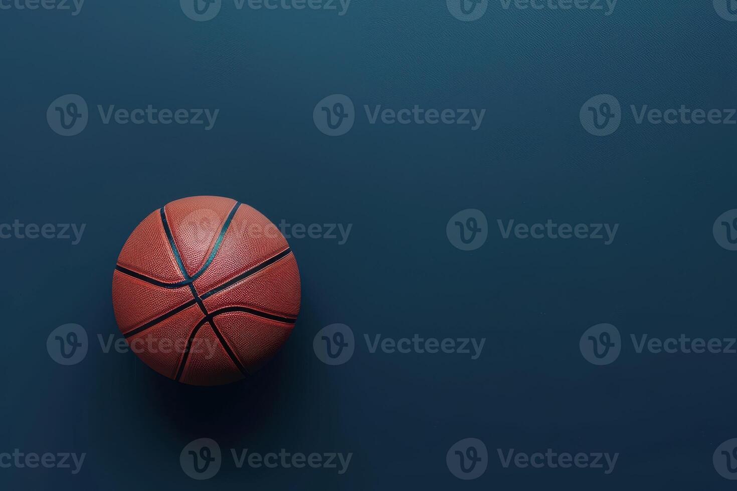 A vibrant basketball resting on a sleek blue surface with dramatic lighting illuminated from above photo