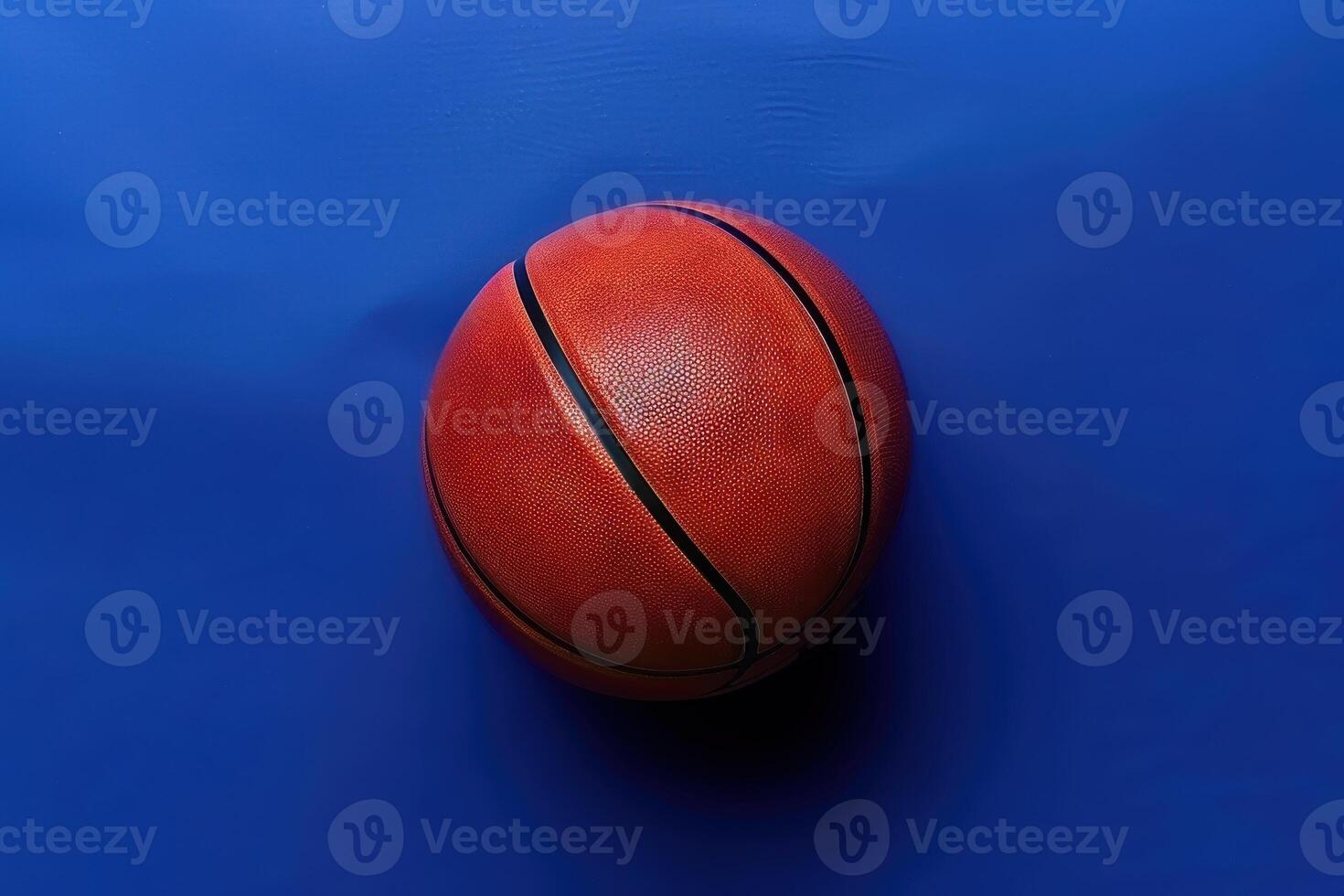 A vibrant orange basketball resting on a blue surface, ready for play in a dynamic sports environment photo