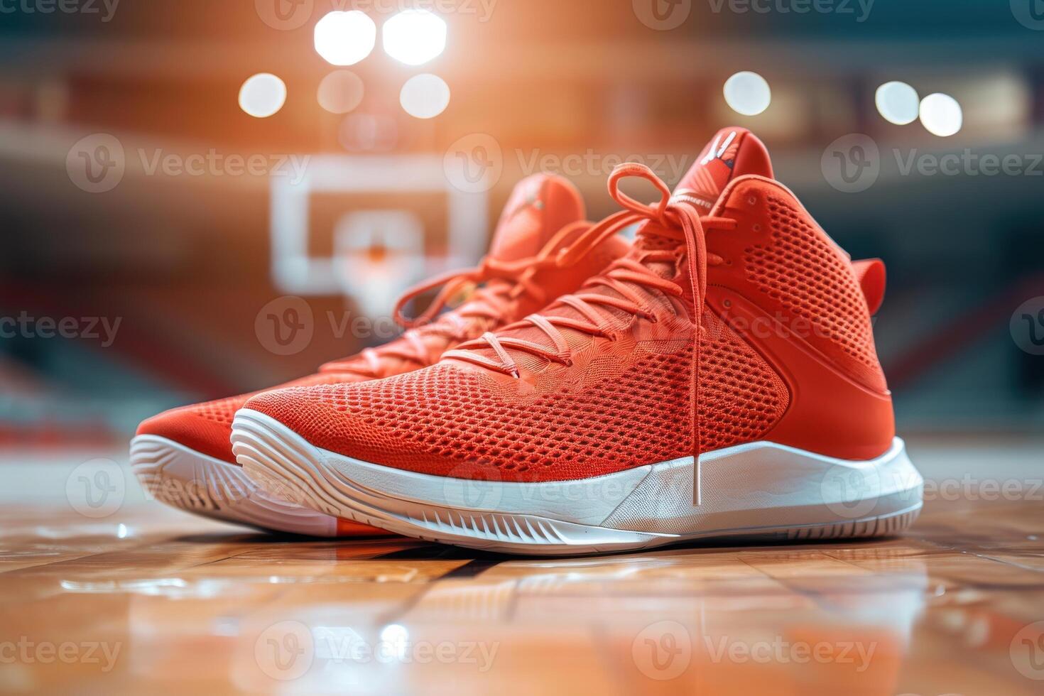 Vibrant red basketball shoes on a hardwood court during a sunset basketball practice session photo