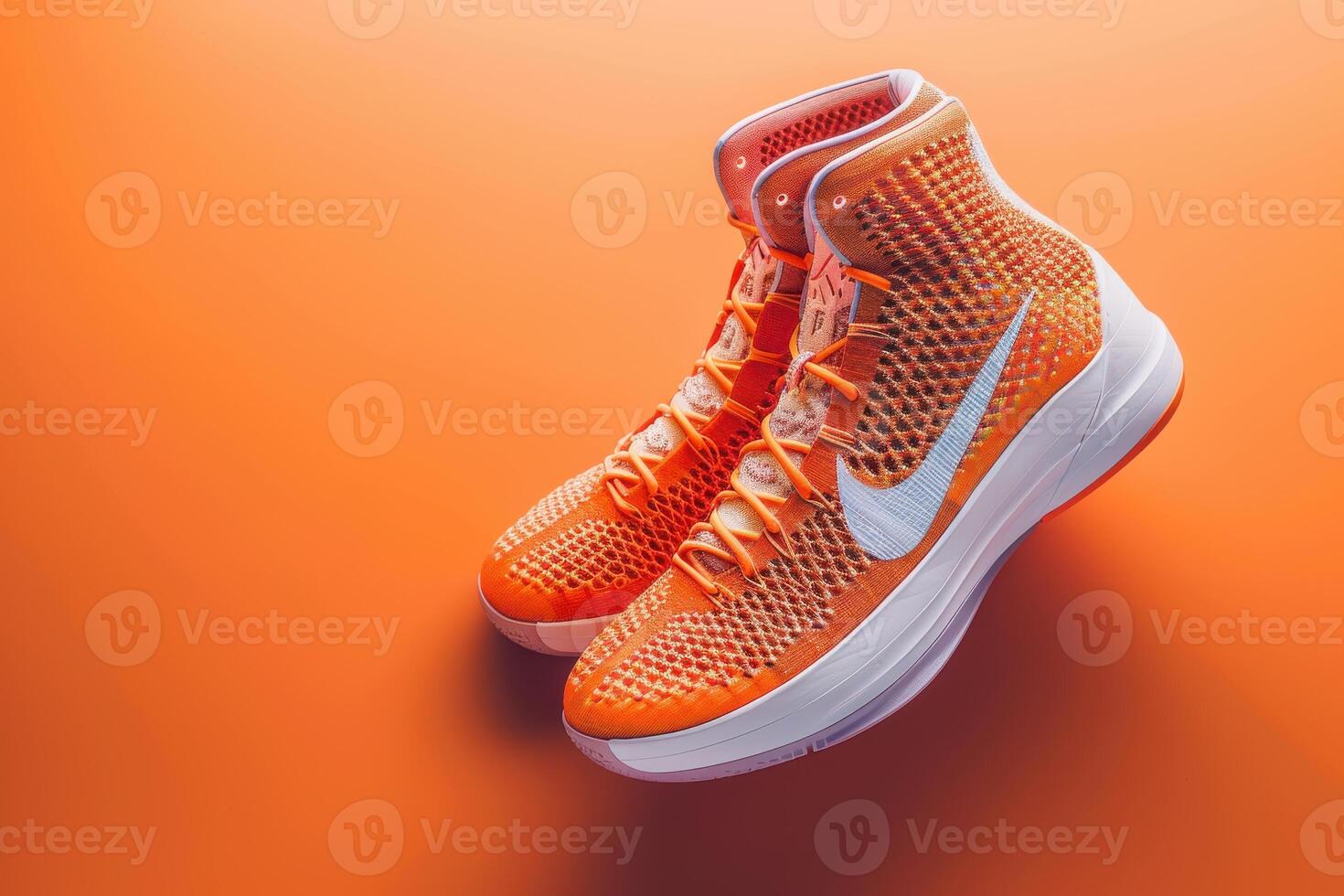 Bright orange athletic sneakers against a vibrant orange background capturing a stylish, dynamic vibe photo