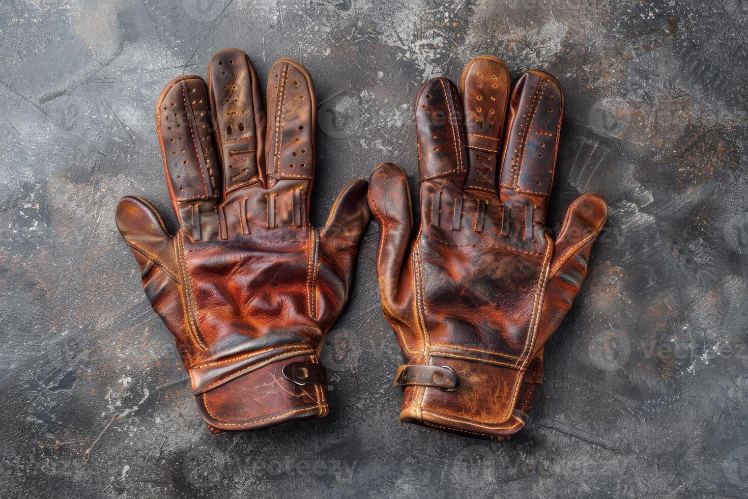 Stylish vintage leather gloves resting on a textured surface, showcasing craftsmanship and wear from a rich history photo