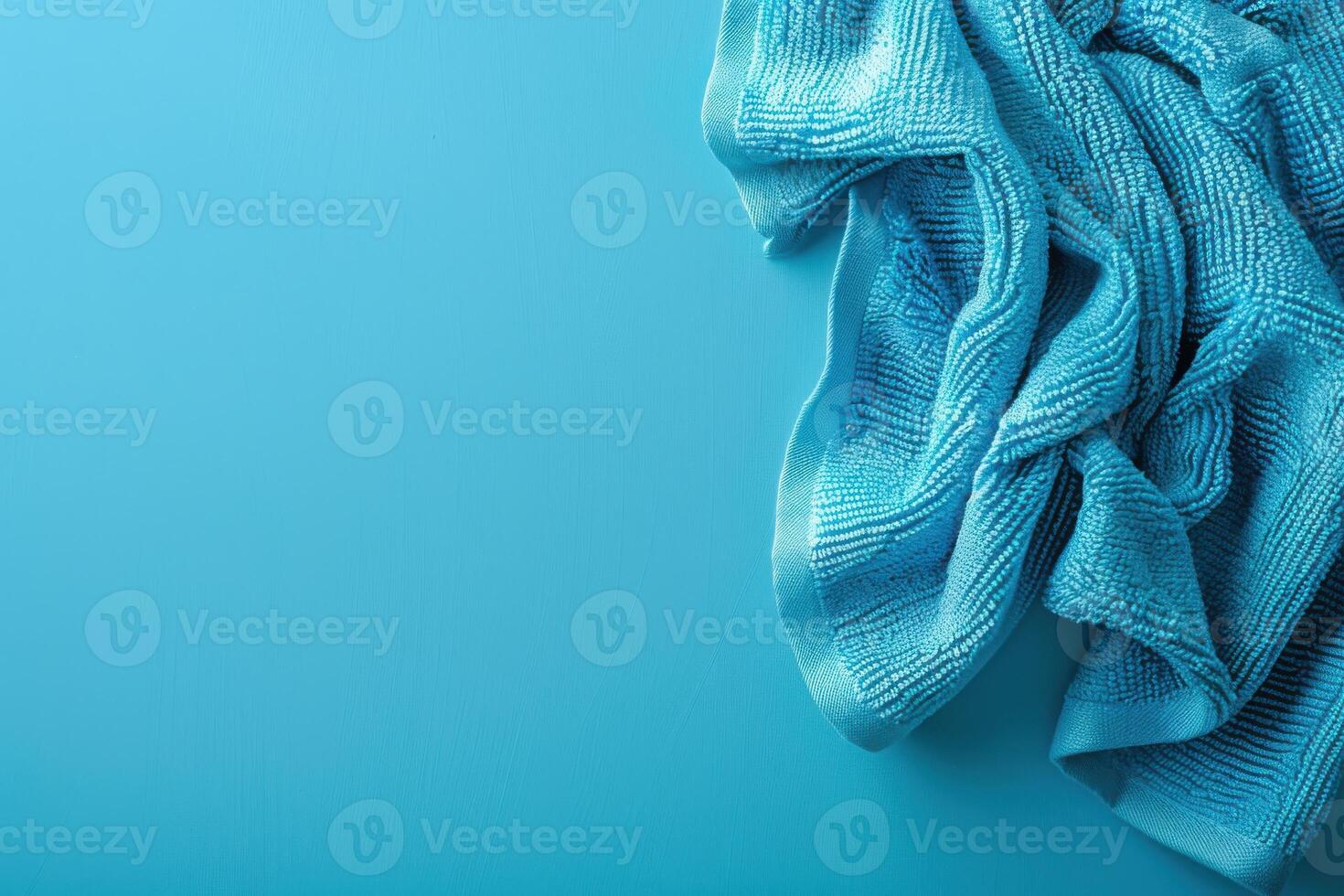 Soft turquoise cloth draped elegantly on a vivid blue background, highlighting texture and color harmony in a minimalist setting photo
