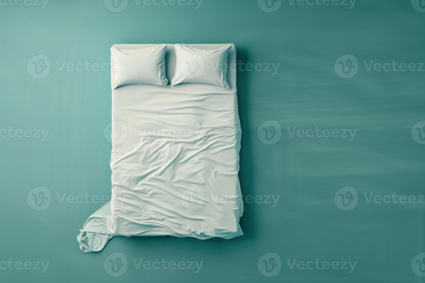 A serene, unmade bed with crumpled sheets and soft pillows against a calming teal backdrop in a cozy bedroom photo