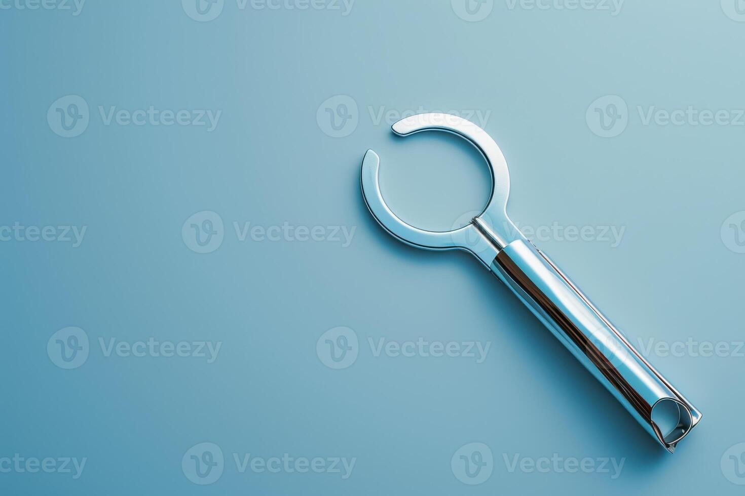 A sleek stainless steel tool resting on a soft blue surface, glinting in the light, showcasing modern design and functionality photo