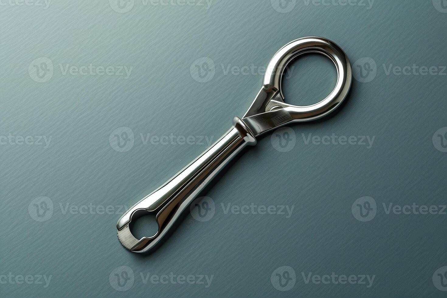 Sleek metallic keyring tool rests gracefully on a smooth dark surface, showcasing its design and functionality photo