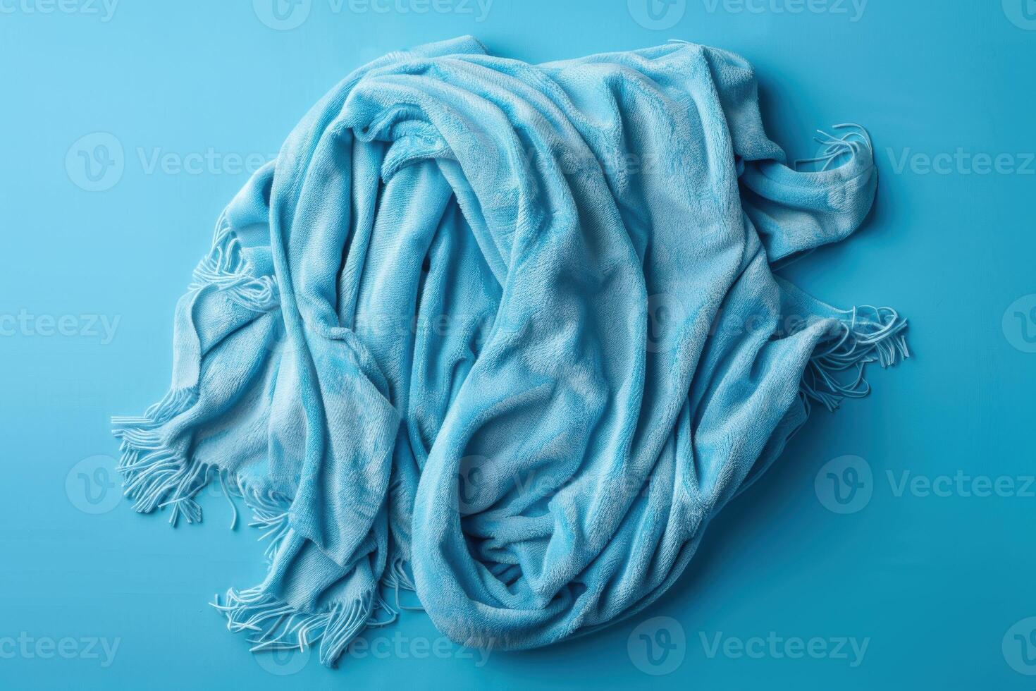 Soft, cozy blue blanket draped elegantly on a vibrant turquoise background photo