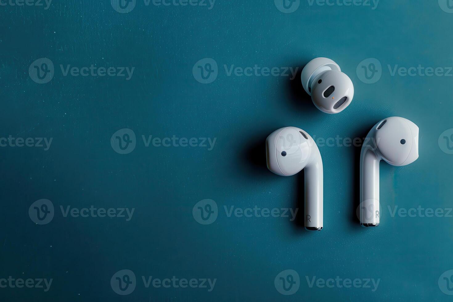 Modern wireless earbuds on a teal background, showcasing sleek design and innovative technology for an immersive audio experience photo