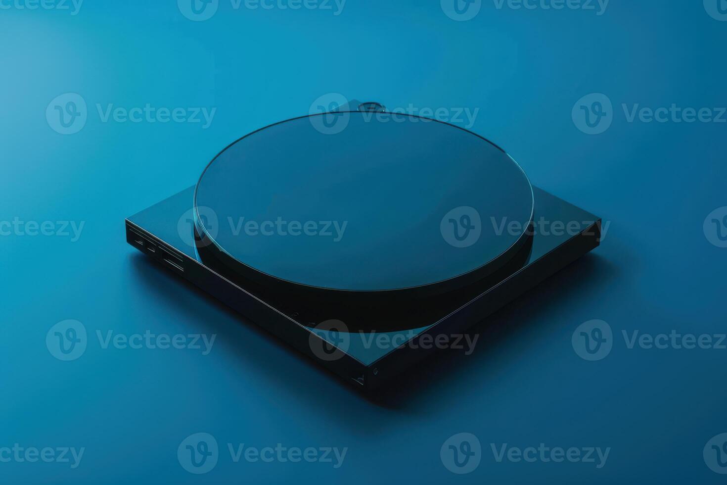 A sleek black turntable spinning softly on a vibrant blue background during a serene evening photo