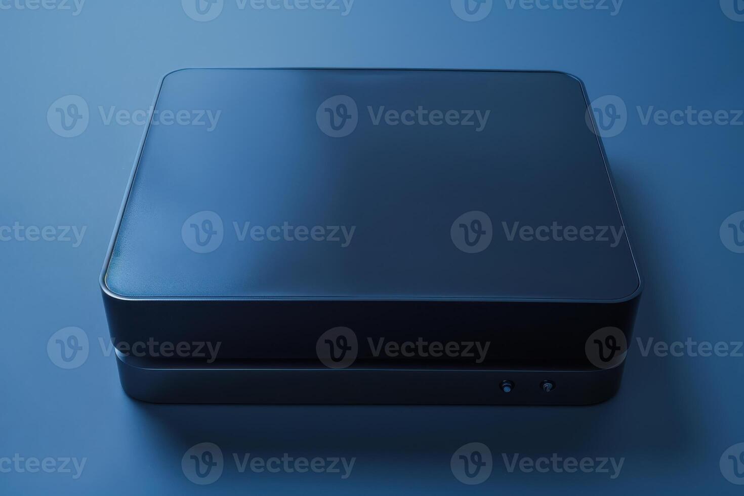 A sleek black device resting on a smooth blue surface in soft ambient light photo