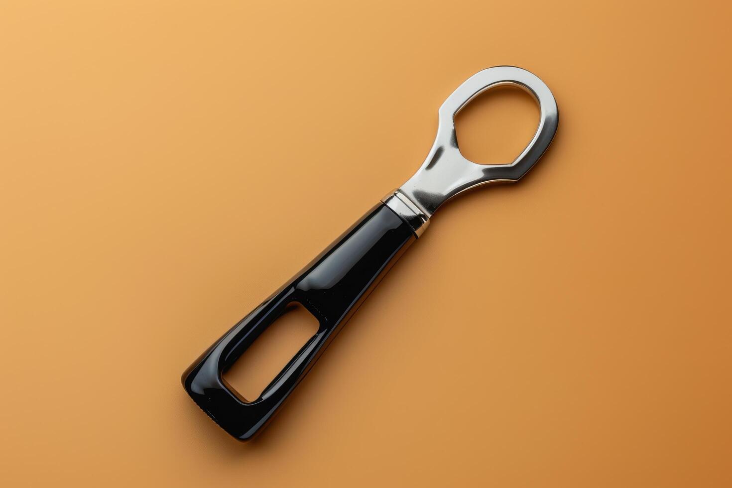 A sleek bottle opener resting on a vibrant orange surface, highlighting its modern design and functional elegance photo