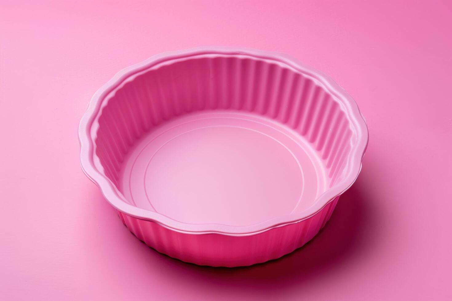 A vibrant pink baking dish sits against a pastel backdrop, ready for culinary creativity in the kitchen photo