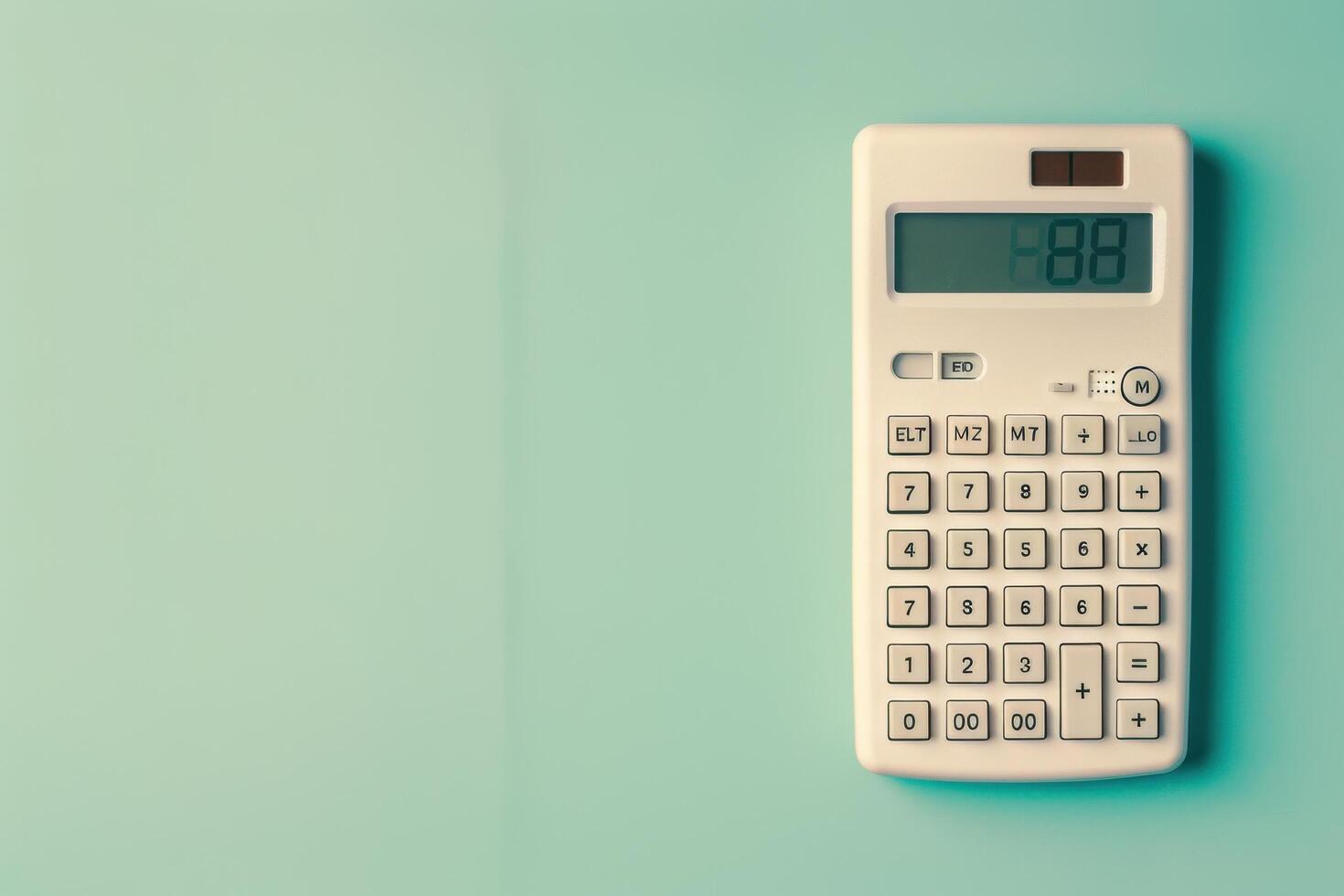 A vintage calculator displaying numbers on a pastel green wall in a cozy workspace setting photo