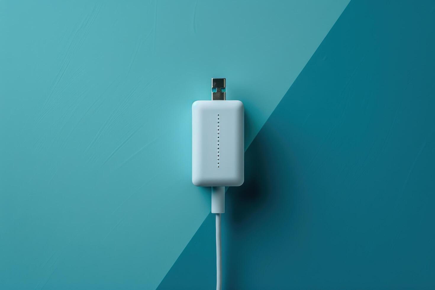 A sleek white USB adapter rests on a vibrant teal background, showcasing modern design in a minimalist setting photo